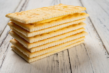 sandwich biscuits with beige cream filling on white wood background