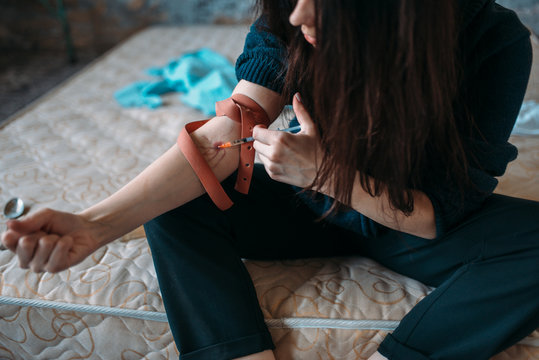 Female junkie with syringe doing an injection dose