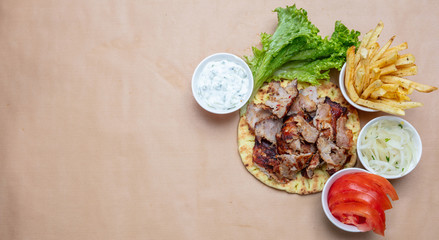 Shawarma, gyros on pita bread, vegetables and tzatziki sauce, top view. Traditional turkish, greek meat food.