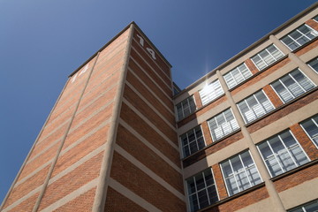 Traditional Zlin red brick building exterior, former shoe factory nowadays museum and gallery of Bata institute, Moravia, Czech Republic, sunny summer day clear sky background