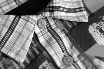 Close up of buttons and collar on a checked flannel shirt, black and white