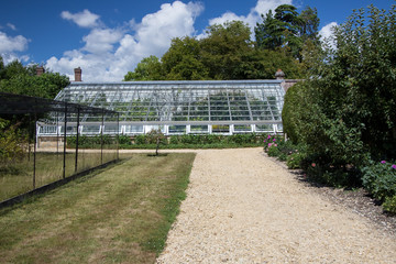 Naklejka premium Large lean-to greenhouse in an English country garden