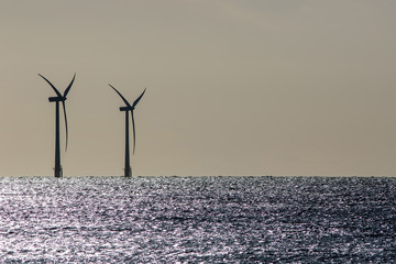 Seascape. Offshore wind farm turbines silhouette on beautiful sea horizon