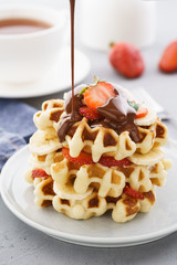 Belgium waffles with strawberries, banana and flowing chocolate.
