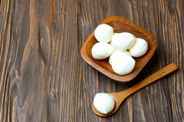 Mozzarella cheese in a wooden bowl on the  table