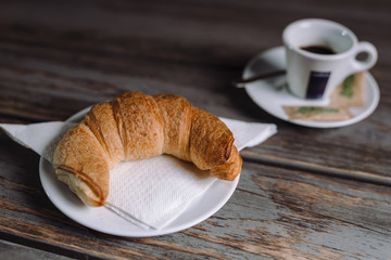 croissant and coffee on wooden table