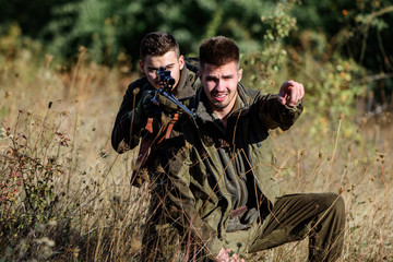 Activity for real men concept. Hunters with rifles in nature environment. Hunters gamekeepers looking for animal or bird. Hunting with friends. Hunters friends enjoy leisure. Teamwork and support