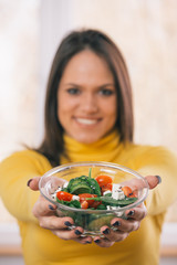 closeup of salad and blurred woman in background