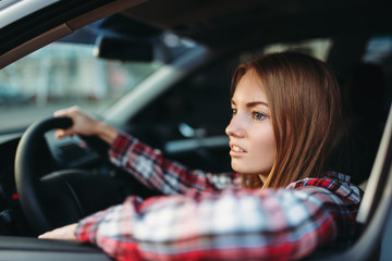 Fototapeta na wymiar Female driver beginner looks out of the car window