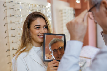 woman optician helping customer. shopping in eyeglasses in optic store