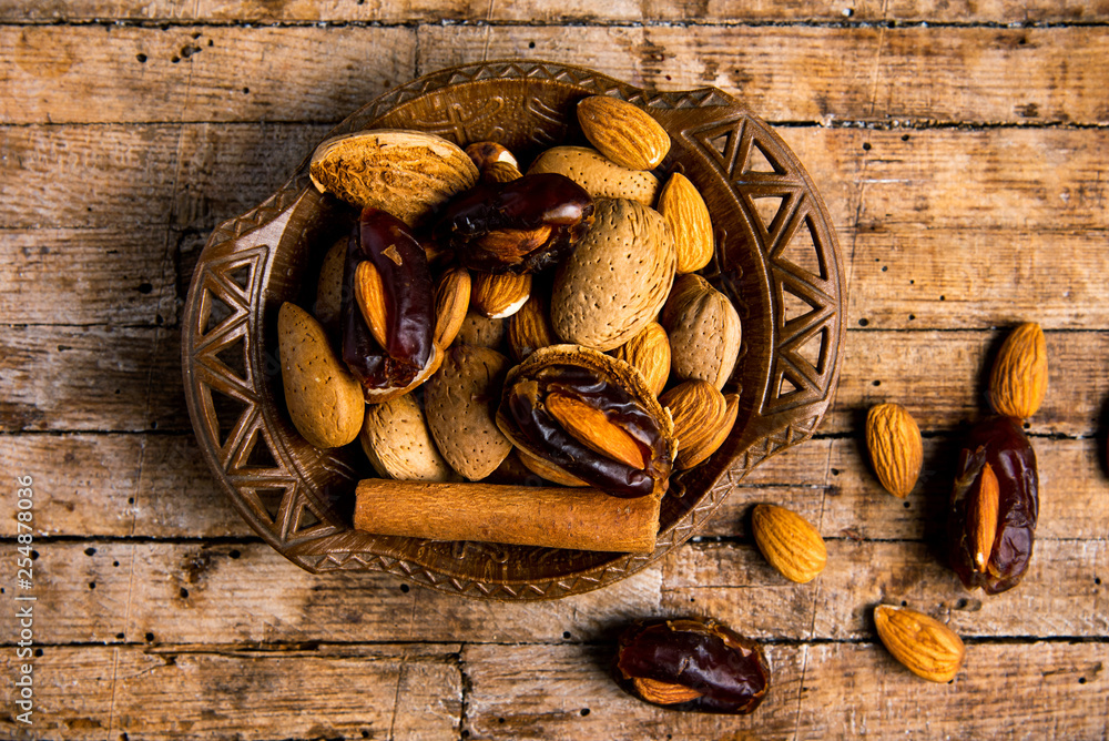 Poster almonds and dates with cinnamon in a bowl