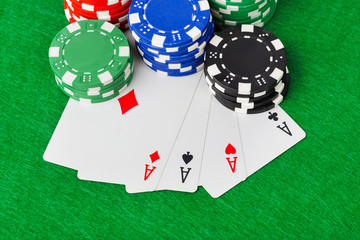 Casino chips and playing cards on green table