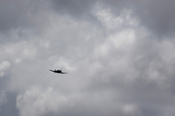 Vintage military plane silhouetted against cloudy sky on the Atherton Tablelands in Tropical North Queensland, Australia
