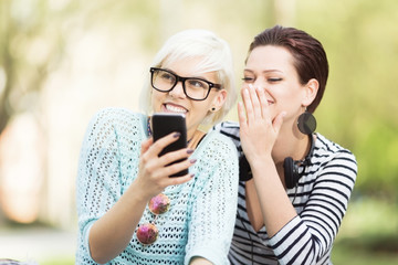 Young happy female students outdoors in campus having a good time