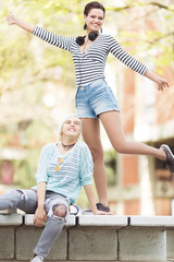 Young female students(one with flower tights) outdoors in campus