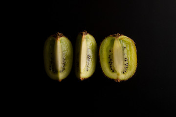 Kiwi fruit isolated on black background, fresh kiwi fruit. Minimalistic fruit background. Healthy food or dessert. Diet, lose weigh. Copy space.