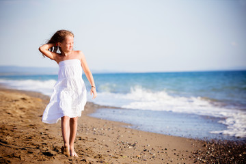 Fototapeta na wymiar Bella bambina camminado lungo il mare