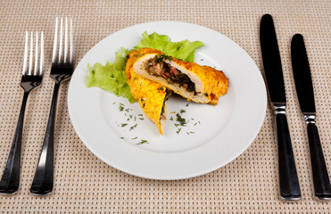 Baked stuffed chicken roll with green salad.