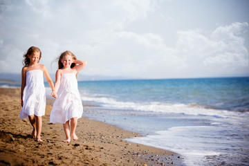 belle bambine a camminare sulla riva del mare