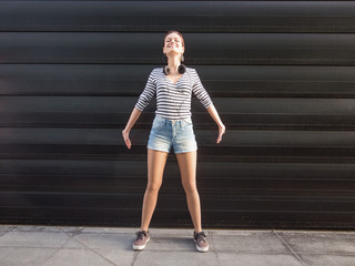 Young woman standing outdoors in front of a camera