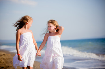 belle bambine a camminare sulla riva del mare