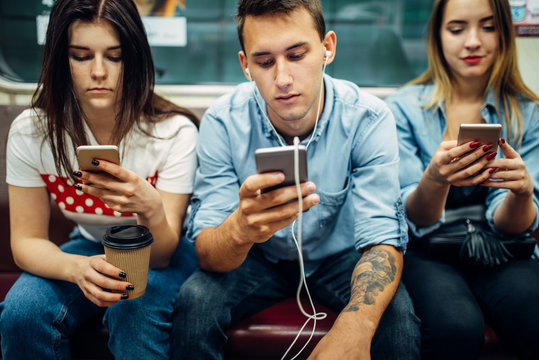 Modern youth using phones in subway, addiction