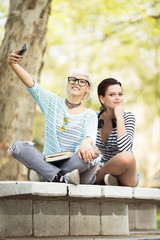 Young and cute female students(one with flower tights) taking selfies in front of a camera