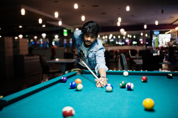 Fototapeta premium Stylish asian man wear on jeans playing pool billiard on bar.