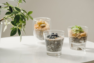 Fruits yogurt parfait with granola and chia seeds for healthy breakfast on wooden table