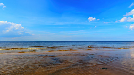 Landscape background with light clouds over Baltic sea near shoreline, selective focus