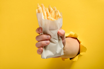 Hand holding French fries