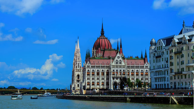 Hungarian parliament building view from river Danube with light clouds at sky, selective focus