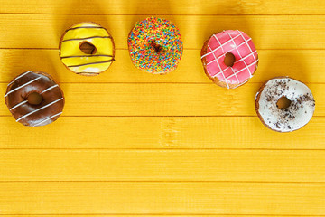 Donuts and confetti on a wooden table.