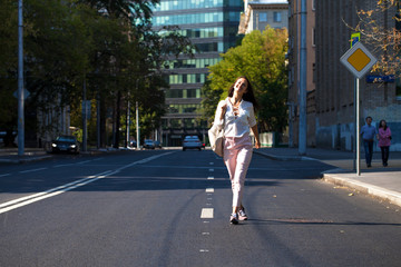 Young beautiful brunette woman walking on the street