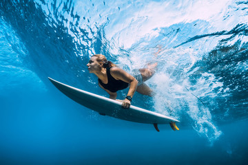Surfer woman dive underwater. Surfgirl dive under big wave - obrazy, fototapety, plakaty
