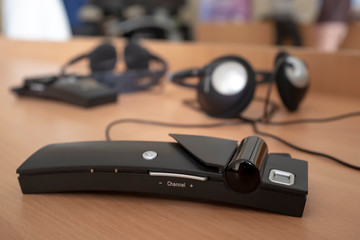 Wireless simultaneous translation system with headphones lies on the table during a lecture at...
