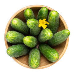 Whole cucumbers in wooden bowl isolated on white. Top view.