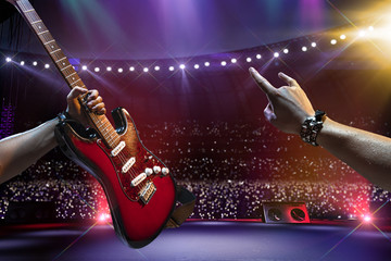 Rock star on the main stage big music festival. Aroun full stadium of spectators. fans are holding flashlights. first person view