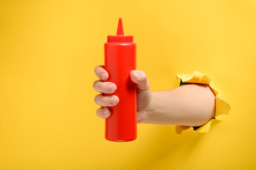 Hand taking a ketchup bottle - Powered by Adobe