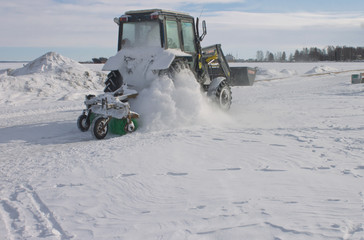 Snow tractor cleans a walkway on a city embankment near a lake in Petrozavodsk,Russia