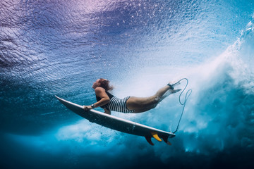 Surfer woman dive underwater. Surfgirl dive under big wave