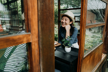 happy young asian girl friends lifestyle moments in traditional japanese wooden house. cheerful smiling chinese female talking chatting sitting on floor drinking tea ceremony beside window door