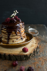 Vegan pancakes with chocolate sauce and  raspberries