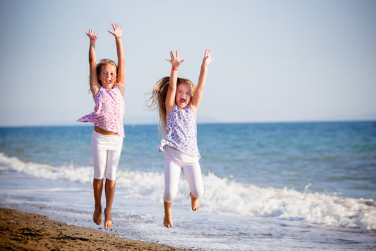 Belle bambine saltando sulla spiaggia