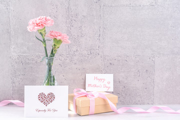 Mothers day handmade giftbox surprise wishes photography - Beautiful blooming carnations with pink ribbon box isolated on gray wallpaper design, close up, copy space, mock up