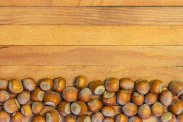 Top view of hazelnuts on wooden background.