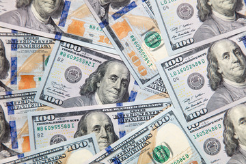 One hundred dollar bills on the table as background