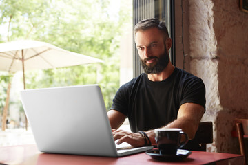 Handsome Bearded Businessman Wearing Black Tshirt Working Laptop Wood Table Urban Cafe.Young Manager Work Notebook Modern Interior Design Place.Coworking Process Business Startup.Color Filter