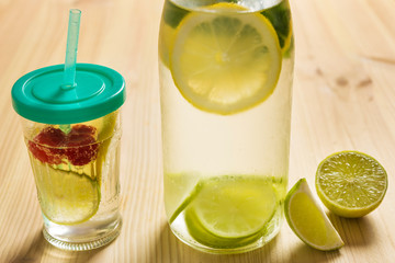 soda with pieces of citric fruits on wooden table