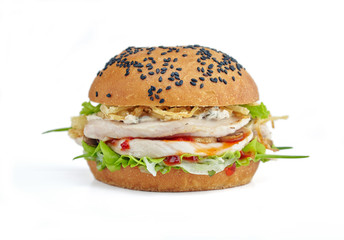 Thai chicken burger with crispy onion and spicy sauce on white background